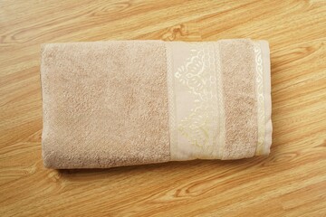 a stack of folded towels on a wooden shelf with a ladder in the background towels on wooden in bath