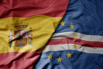 big waving national colorful flag of spain and national flag of cape verde .