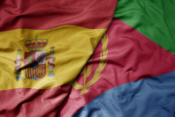 big waving national colorful flag of spain and national flag of eritrea .