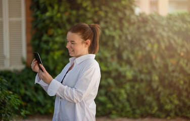 Woman looking at her cell phone and smiling and checking her mail