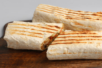 Board with tasty shawarma on grey background
