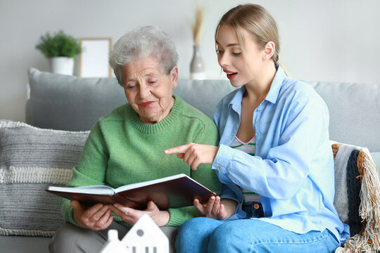 Young woman and her grandmother with photo album at home