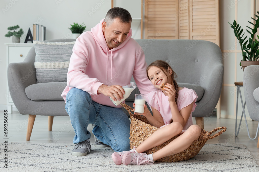 Poster Little girl with her father sitting on floor and drinking milk in living room