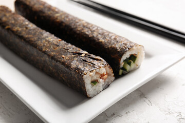 Plate with tasty maki rolls on light background, closeup