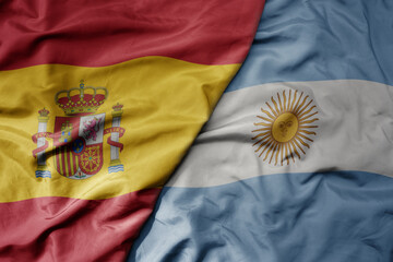 big waving national colorful flag of spain and national flag of argentina .
