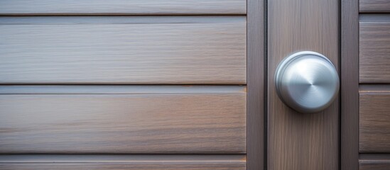 Silver stainless steel door knob on gray wooden entrance door seen from a horizontal angle