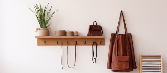 Stylish accessories and wooden hanger for keys on a beige wall in an interior hallway