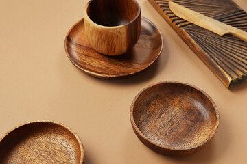 Different wooden tableware on brown background, closeup