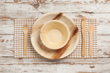 Different tableware on light wooden background