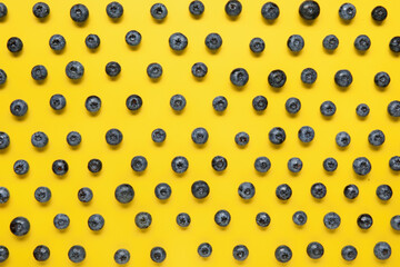 Many fresh blueberries on yellow background