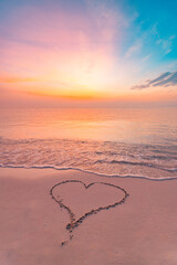 Heart on beach drawn in sand. Amazing sea sunrise view with a cozy romantic hand drawn heart as...