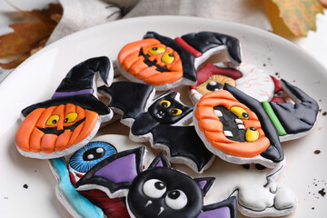 Plate with different tasty cookies for Halloween celebration on light background, closeup