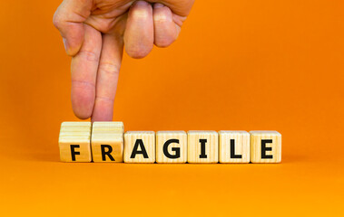 Agile or fragile symbol. Concept words Agile and Fragile on wooden cubes. Beautiful orange table...