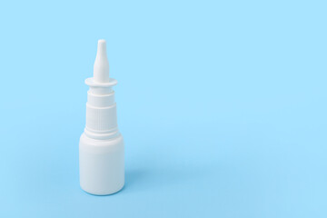 Bottle of nasal drops on blue background