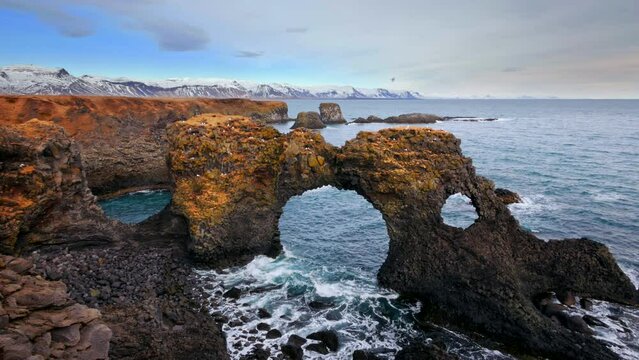 Wave crashing through Natural rock gate in Arnarstapi, Snafellsnes peninsula, Iceland