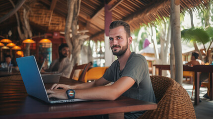 Fototapeta premium Young lifestyle digital nomad working on the laptop at the cafe island