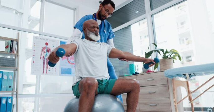 Senior care, physiotherapist and old man with dumbbell, ball and support in healthcare rehabilitation. Physio, fitness coach or caregiver with elderly patient in mobility training clinic for pain