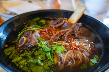 Slow cooked beef short rib with egg noodles, bone marrow broth, Chinese Broccoli, cilantro, basil, onion, chicharron garlic oil
