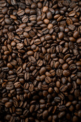 Top view of dark brown fresh roasted coffee beans background. Copy space
