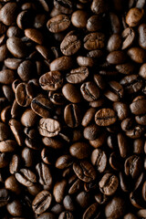 Close up view of dark brown fresh roasted coffee beans background. Copy space