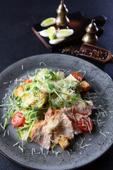 Salad with shrimp. Caesar salad with shrimp.On dark background. Without people. Vertical photography.