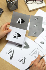 A graphic designer develops a logo for a brand. The illustrator draws sketches on paper.	 - 639394421