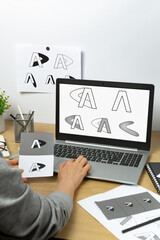 A graphic designer develops a logo for a brand on laptop. - 639394423