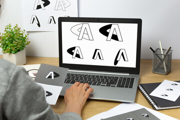 A graphic designer develops a logo for a brand on laptop. - 639394426