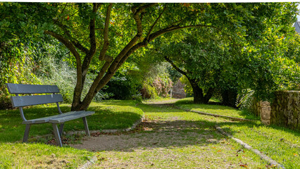 A bench in shade in a park in Brittany, France