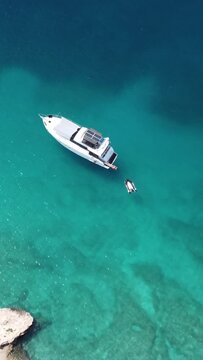 Drone shot of a white yact sailing off the coast of Turkey.