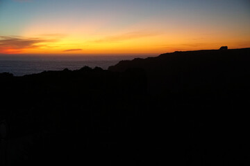 silhouette of camper vans parking on cliff during sunset  