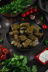 Delicious dolma on a dark background stuffed grape leaves rice. Traditional Caucasian, Turkish and Greek cuisine