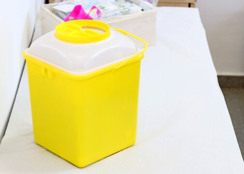 A container of sharps or biological waste on the stretcher of a medical consultation