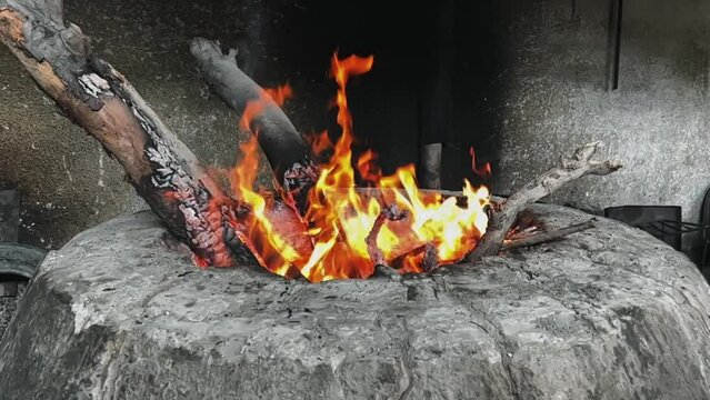 Burning firewood in a tandoor. Preparing the tandoor for cooking meat. Barbecue outdoors. Slow motion video