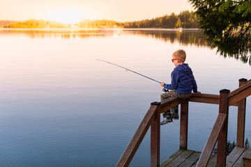 Boy fishing on a lake at sunset. Location Puget sound Washington state  