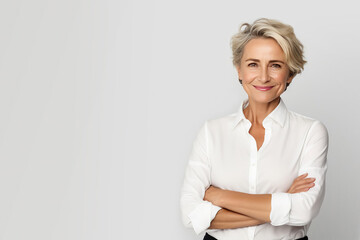 Mature business woman smiling confident with arms crossed looking like a corporate senior manager or an experienced female entrepreneur with positive energy standing against a white background.