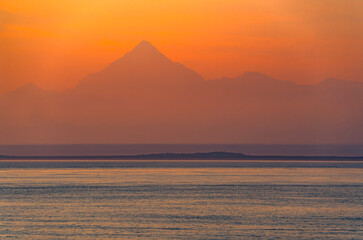 mountain silhouette under sunrise sky and Alaska ocean