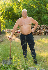 an elderly active man in the forest prepares firewood, uses a smartphone laptop