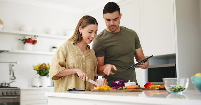 Food, tablet and a couple cooking in the kitchen of their home together for health or nutrition. Diet, love or smile with a man and woman preparing a meal with vegetables for wellness or hunger