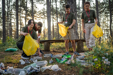 teenage friends young men women pick up waste garbage to clean forest
