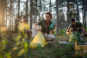 teenage friends young men women pick up waste garbage to clean forest