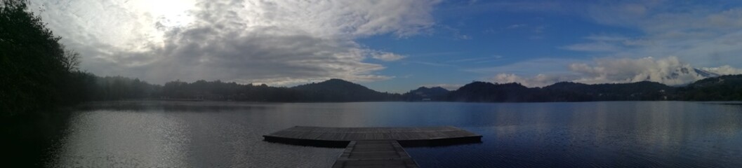 panoramic photo of a romantic wooden jetty on the shore of a lake