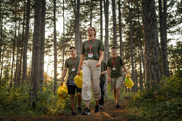 Naklejka na ściany i meble teenage friends young men women pick up waste garbage to clean forest