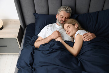 Lovely mature couple sleeping together in bed at home, above view