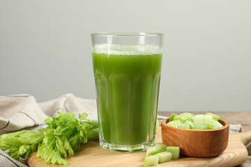 Glass of celery juice and fresh vegetables on table