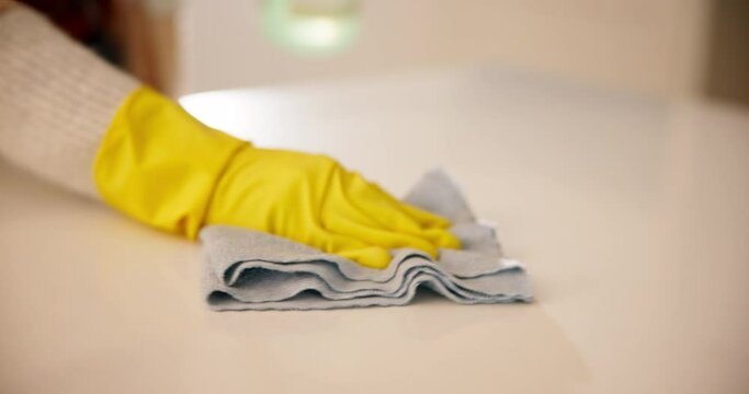 Woman in headphones in kitchen cleaning with gloves, spray bottle and smile, working and listening to streaming radio. Music, housework and happy housewife with chores to wipe dust or dirt in home.