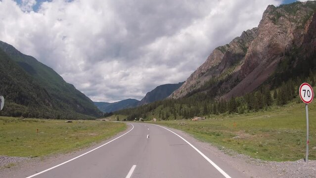 Driving in a car along the mountain road of the Chuya Highway or the Chuysky Trakt in Altai. Siberia, Russia