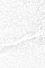 White water with ripples on the surface. Defocus blurred transparent white colored clear calm water surface texture with splashes and bubbles. Water waves with shining pattern texture background.