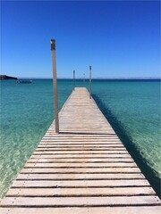 wooden pier in the clear blue green sea