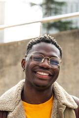 Vertical portrait of attractive black male college student looking at camera smiling. Copy space.